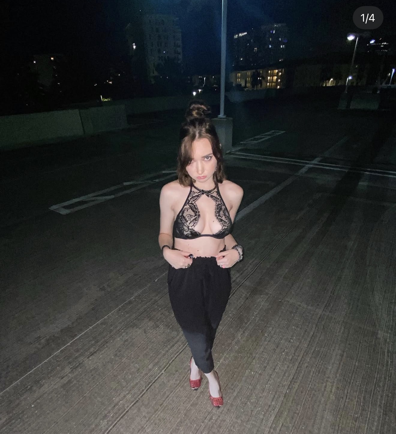 Anna in a black lace halter top on a rooftop at night