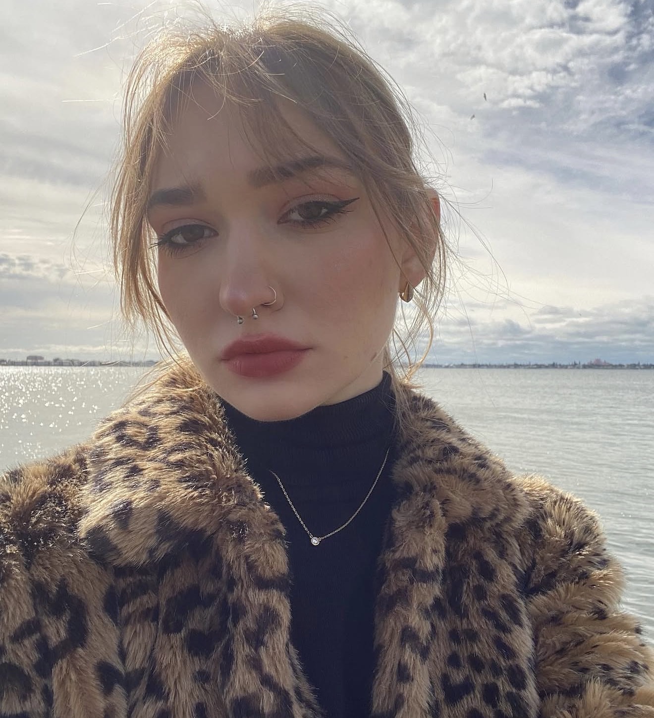 Anna in a leopard print fur coat by the water